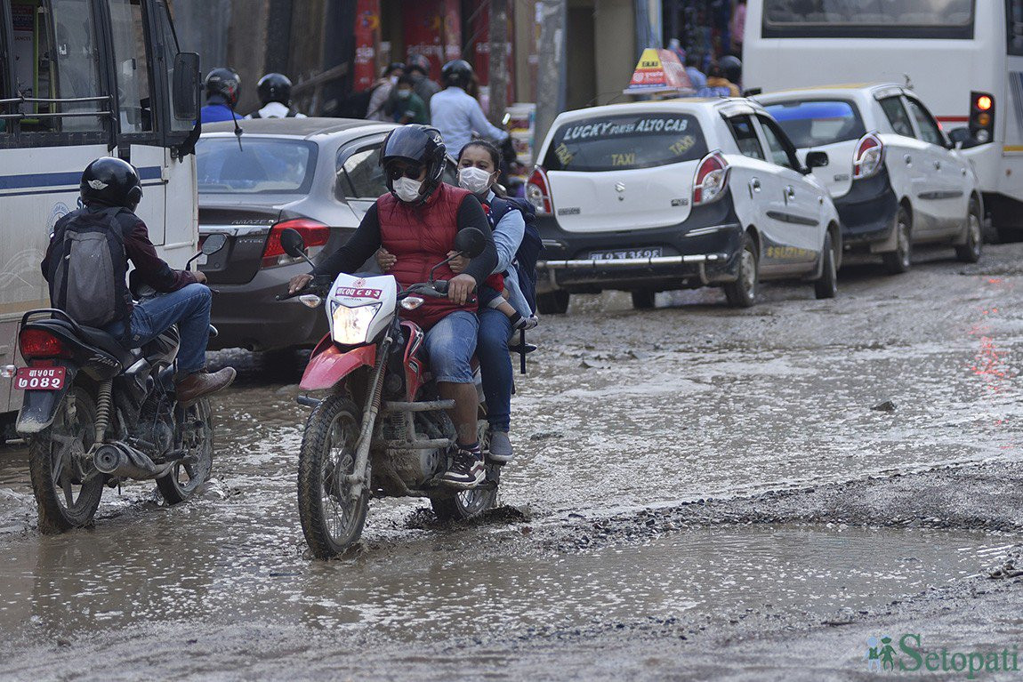 बौद्ध सडकमा टिलपिल जमेको हिलोमाथि ढलपल सवारी। यो सडक चार वर्षदेखि यस्तै जीर्ण र अस्तव्यस्त छ। फाइल तस्बिर : नारायण महर्जन/सेतोपाटी