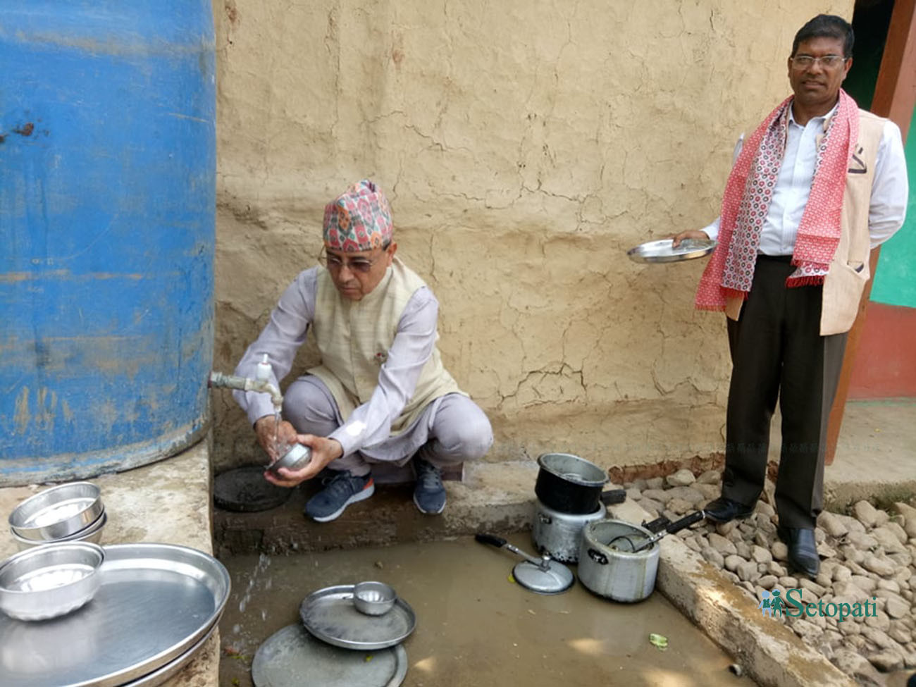 शुक्रबार बिहान पञ्चपुरी नगरपालिका वडा नं. ८, दुलालथाइस्थित लक्ष्मी सुनारको घरमा खाना खाएपछि भाँडा धुँदै कांग्रेस महामन्त्री पूर्णबहादुर खड्का, साथमा केन्द्रीय सदस्य जीवनबहादुर शाही। तस्बिरः दिपक