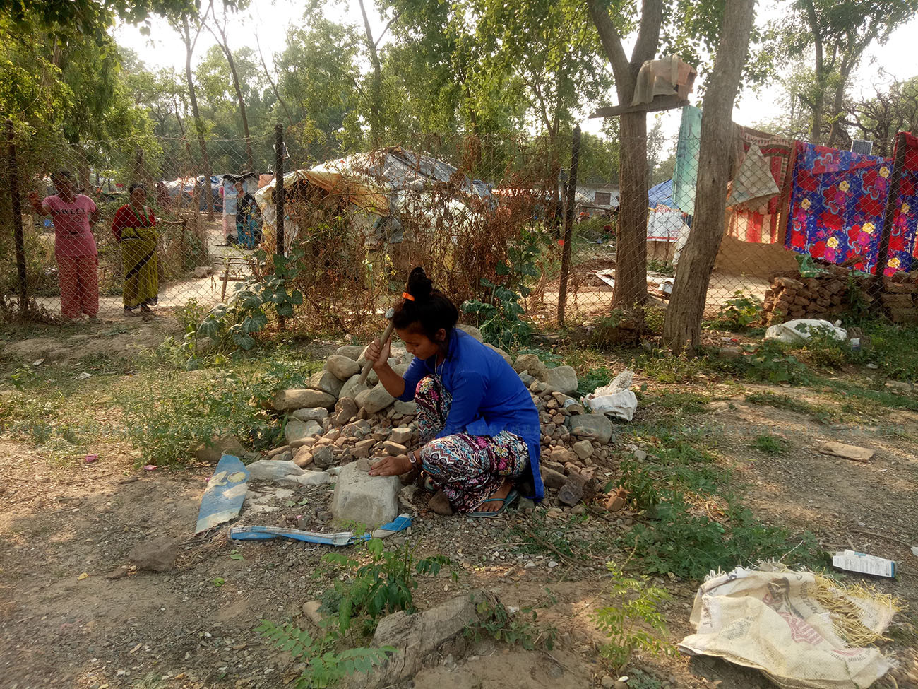 गिट्टी कुट्दै सुर्खेतको वीरेन्द्रनगरमा रहेको बाढीपीडित शिविरमा बस्दै आएकी दिपा शाही। तस्वीरः दिपकजंग शाही/सेतोपाटी