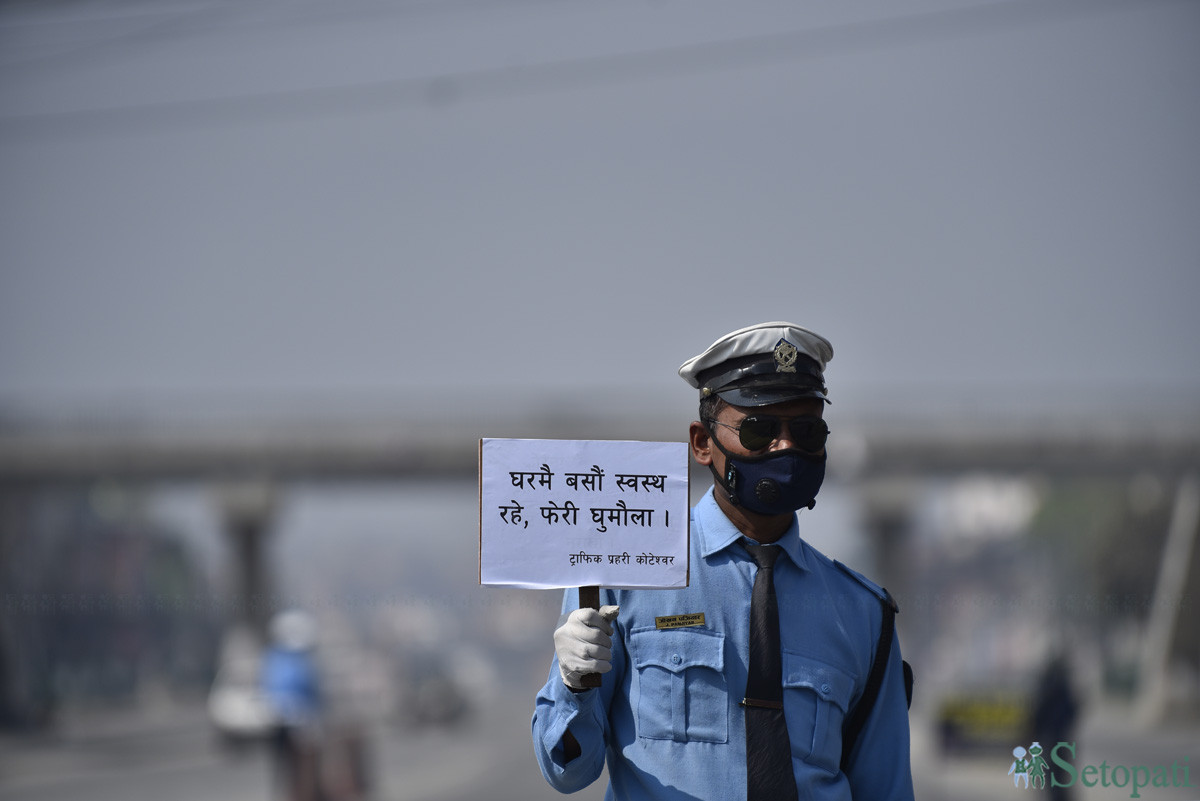 काठमाडौंमा बिहीबार लकडाउनमा घर बसौं सन्देश बोकेका ट्राफिक प्रहरी। तस्बिरः नारायण महर्जन/सेतोपाटी