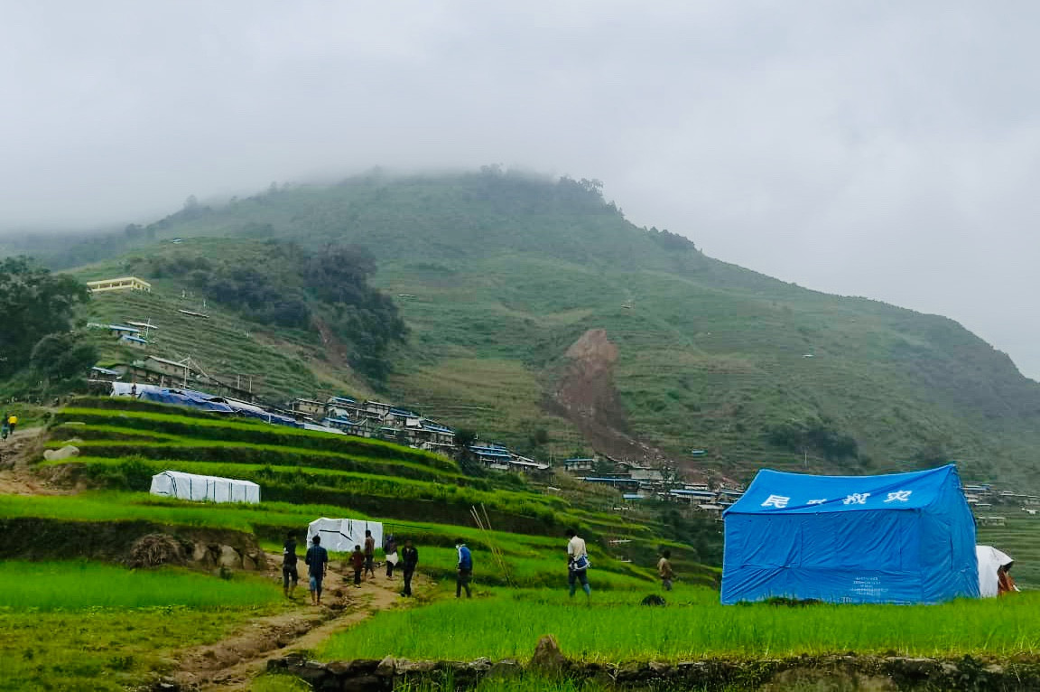 शुक्रबार पहिरो गएको सिन्धुपाल्चोक, जुगल गाउँपालिका- २ को लिदी गाउँ। अगाडि देखिएका नीलो र सेता टेन्टहरू स्थानीयले पहिरो जानुअघि नै बसोबास गर्न बनाएका हुन्। तस्बिर स्रोत: अनिल पोखरेल