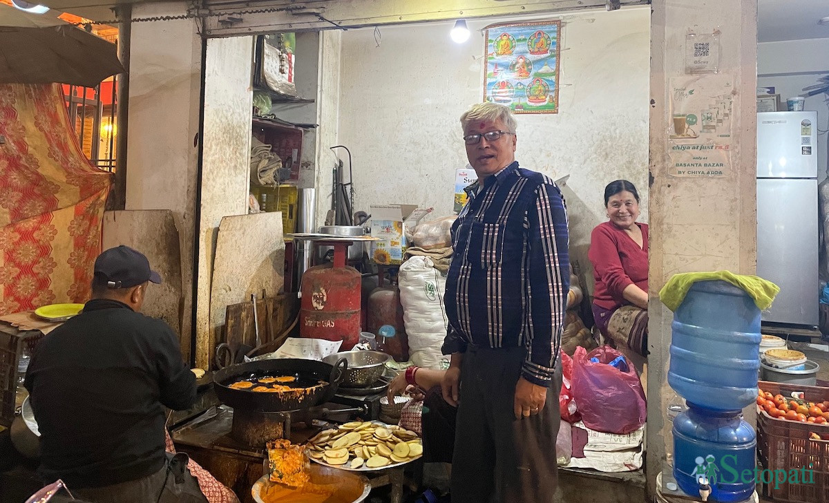 ओमबहालको आलुचप पसल र यसका सञ्चालक आशाकाजी महर्जन। तस्बिर: आर्या श्रेष्ठ/सेतोपाटी