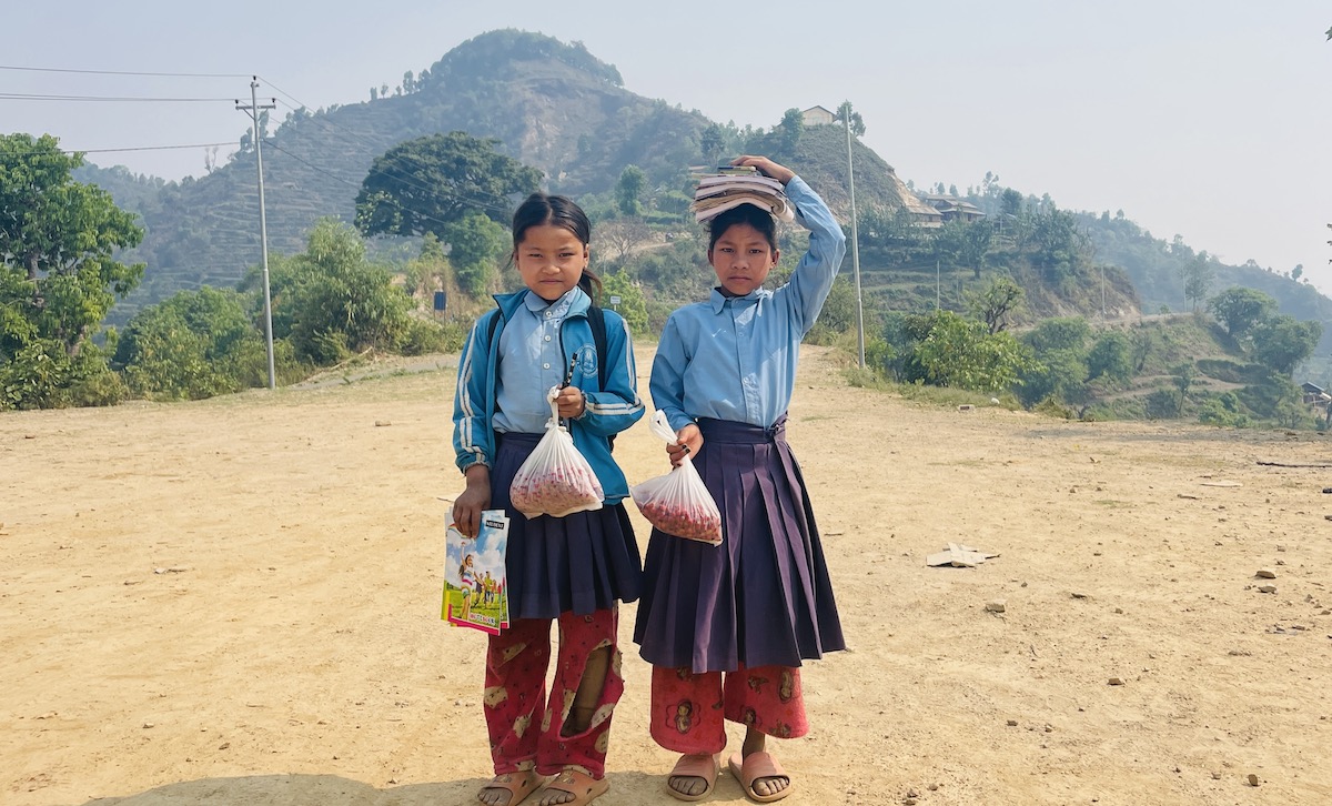 काफल र किताब लिएर विद्यालय जाँदै गरेका सन्जिता चेपाङ र  विष्णुमाया चेपाङ। तस्बिर: राजेश घिमिरे/सेतोपाटी
